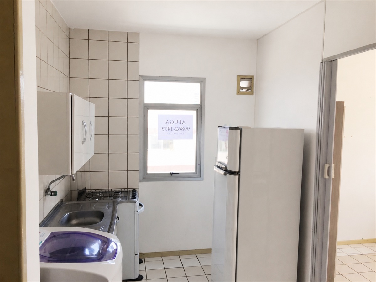 Cozinha com geladeira, fogão e máquina de lavar